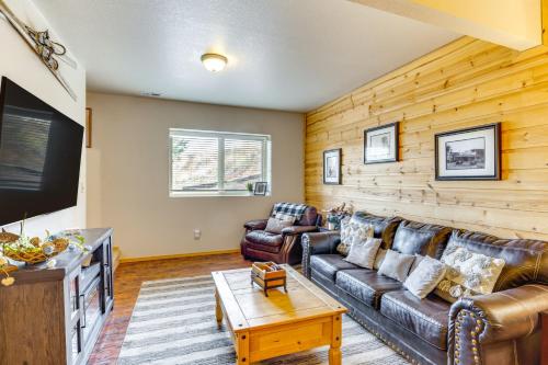 a living room with leather furniture and a flat screen tv at Lakefront Divide Cabin with Game Room! in Woodland Park