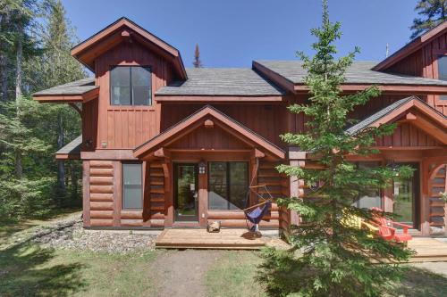 a log cabin with a porch and a tree at Family friends lake access & hot tub in Lac-Superieur