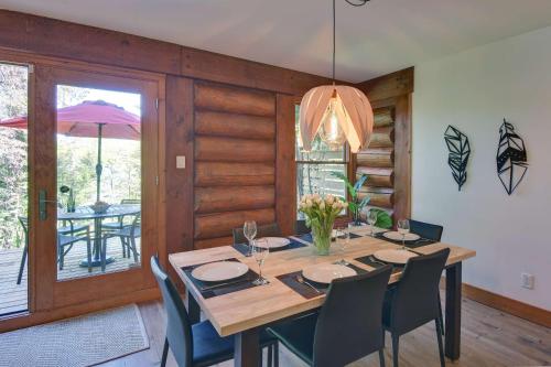 a dining room with a large wooden table and chairs at Family friends lake access & hot tub in Lac-Superieur