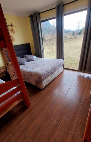 a bedroom with a bed and a large window at Cabaña viejo Roble in Trape