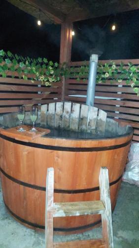 a wooden barrel with a chair and wine glasses at Cabaña viejo Roble in Trape