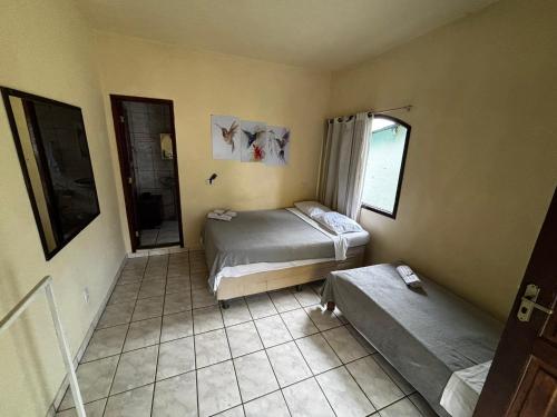 a small bedroom with a bed and a window at Encanto do Beija-flor in Angra dos Reis