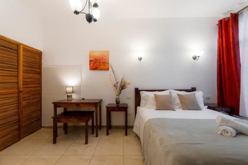 a bedroom with a bed and a table with a desk at Habitación doble económica - Casa Esmeralda in San José