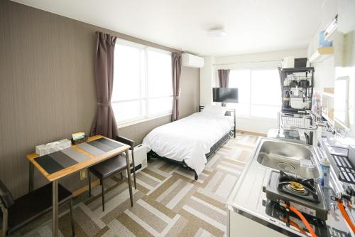 a hospital room with a bed and a desk at バンビハイツ長島305 in Aomori