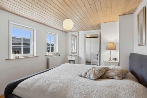 HarboørにあるCozy Holiday Home In Harboøreの大きなベッドと2つの窓がある寝室