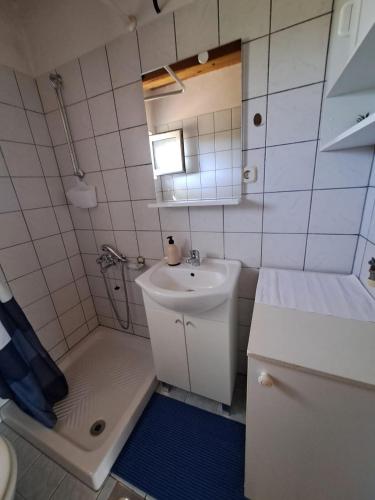 a small bathroom with a sink and a shower at Secluded fisherman's cottage Krknata, Dugi otok - 397 in Žman