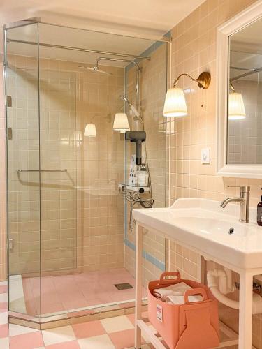 a bathroom with a shower and a sink at Roots House in Busan
