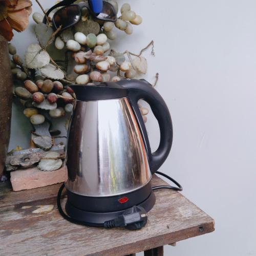 a tea kettle on a table with a bunch of grapes at Ban Kru Ae HomeHostel in Bangkok