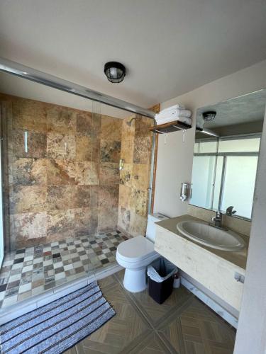 a bathroom with a toilet and a sink and a tub at La Altanera in Troncones