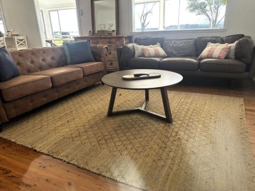 a living room with a couch and a coffee table at Sea Breeze Escape - Pet-Friendly Escape - Book 3, Pay for 2! in Greenwell Point