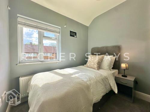 a bedroom with a white bed and a window at Premium 3BR House, French Doors and Private Garden in Borehamwood