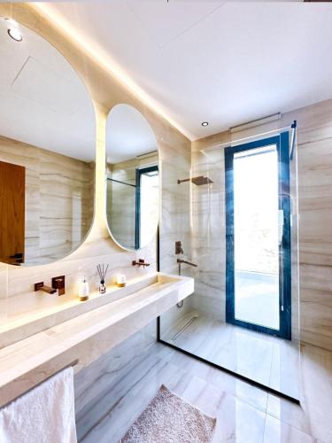 a bathroom with a large mirror and a sink at Modern Villa Assia in Marrakech