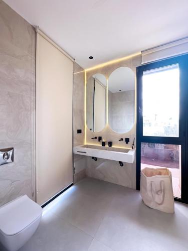 a bathroom with a toilet and a sink and a window at Modern Villa Assia in Marrakech