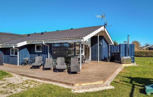 a wooden deck with chairs and a house at Four-Bedroom Holiday Home In Hadsund in Nørre Hurup