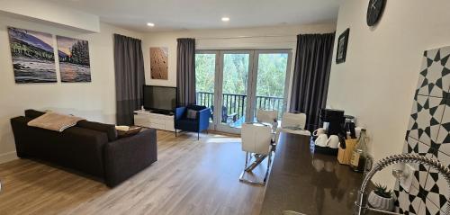 a living room with a couch and a television at Casa del Rio - Peaceful River Guest Suite -Forests -Mountains -Hiking in Chilliwack