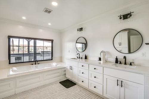 a white bathroom with a tub and two sinks and a window at Pool, Spa and City Views Luxe Home in San Diego! in San Diego