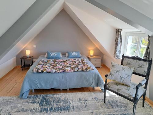 une chambre avec un grand lit et une chaise dans l'établissement Stone House by Beach in Pont-Aven, à Trégunc