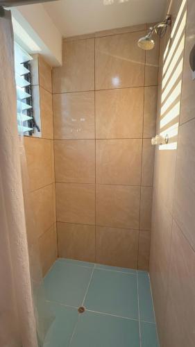 a bathroom with a shower with a blue floor at Vertigo Climbing Hostel in Urubamba