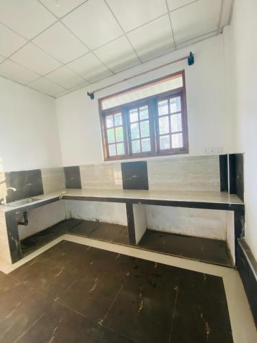 an empty room with a table and a window at Pilgrims Rest in Polonnaruwa