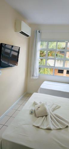 ナタールにあるYacht Village Praia JRの白いベッド(タオル付)