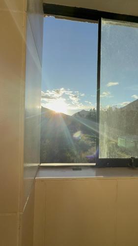 a window with a view of a mountain view at Vertigo Climbing Hostel in Urubamba