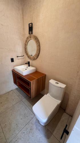 a bathroom with a toilet and a sink and a mirror at Hotel Renata in Mazunte
