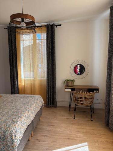 a bedroom with a bed and a table and a desk at Family home with spa near Chantilly Paris in Angy
