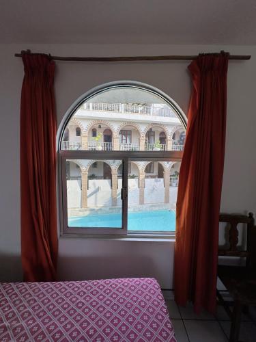 a bedroom with a window with a view of a building at Hotel San Juan in Puerto Escondido