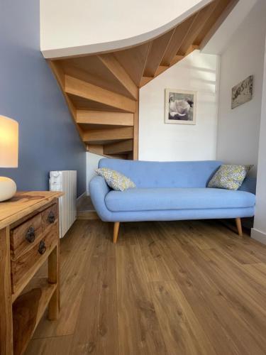 a living room with a blue couch and wooden floors at Plein centre Auray - Grand duplex 2 chambres avec terrasse ensoleillée in Auray