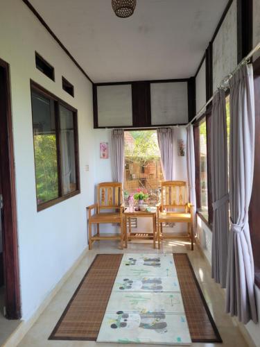 a room with two chairs and a table with a rug at D'Langun Bali in Munduk