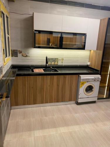 a kitchen with a washer and a washing machine at Wealthy in Madīnat ash Shurūq