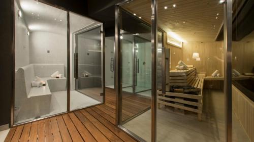 uma casa de banho com um chuveiro e uma banheira com paredes de vidro em Ville Saint Germain Apart Hotel & Spa em Carilo