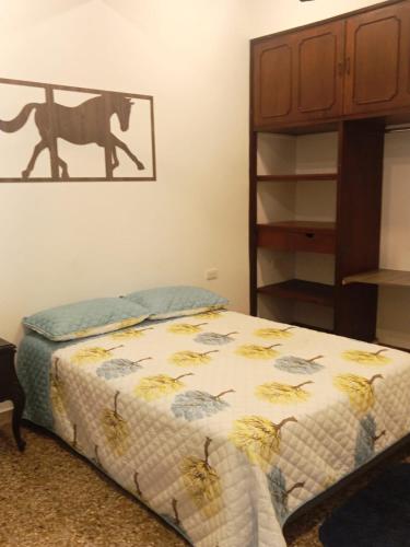 a bed in a bedroom with a picture of a horse on the wall at HOTEL GANADERO in La Dorada