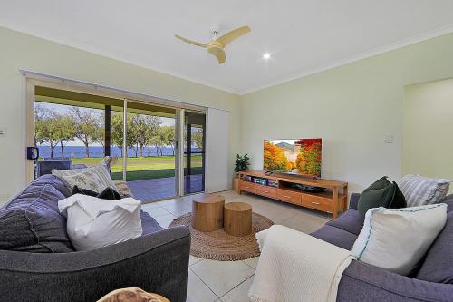 a living room with two couches and a tv at Elliott on the Rocks in Elliott Heads