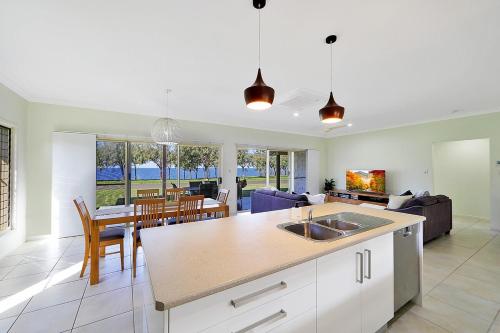a kitchen and living room with a table and a couch at Elliott on the Rocks in Elliott Heads