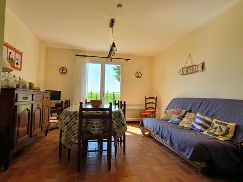 un salon avec une table et un canapé dans l'établissement Maison agréable entre mer et campagne, proche plage et centre-ville, animaux permis - FR-1-476-98, à Grues