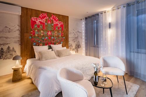 a bedroom with a large bed and two chairs at Moments de douceur - Suite Laponie et Suite Tahiti in Boulieu-lès-Annonay