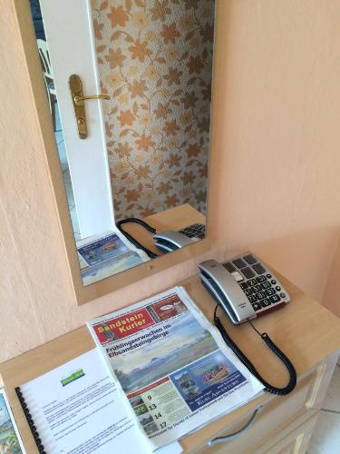 a telephone sitting on a table in front of a mirror at Pension Hönel-Hof Bad Schandau in Bad Schandau