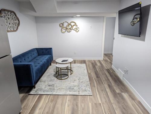 a living room with a blue couch and a table at Chic 2BR Suite with Kitchen, Laundry, Near Elk Island & West Edmonton Mall in Edmonton