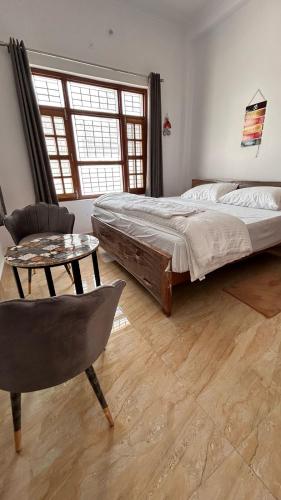 a bedroom with a bed and a table and a chair at Happy Inn in Faizābād