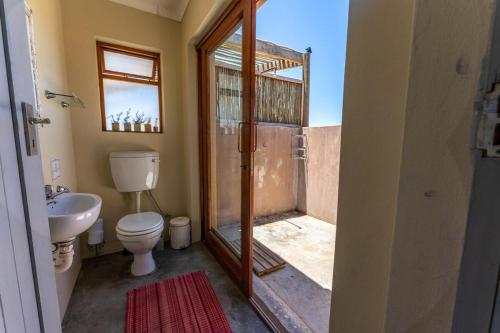 a bathroom with a shower with a toilet and a sink at Bobbejaankrans, Touwsberg Game and Nature Reserve in Plathuis