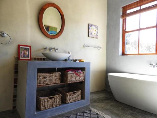 a bathroom with a tub and a sink at Bobbejaankrans, Touwsberg Game and Nature Reserve in Plathuis