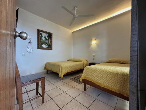 a hotel room with two beds and a table at Hotel San Juan in Puerto Escondido