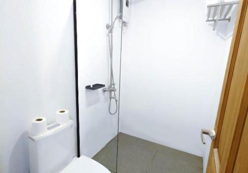 une salle de bain avec toilettes et douche en verre dans l'établissement 89 Villas Resort and Spa, à El Nido