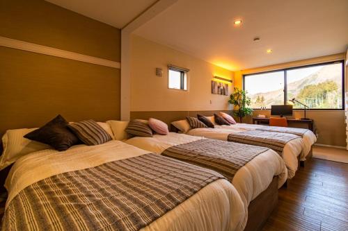 a row of beds in a room at MIRISE Sky Villa & Sauna in Minakami