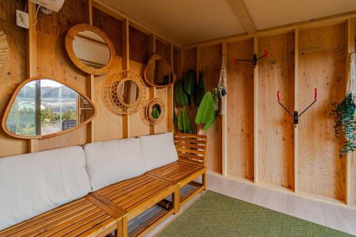 a bench in a room with wooden walls and mirrors at MIRISE Sky Villa & Sauna in Minakami