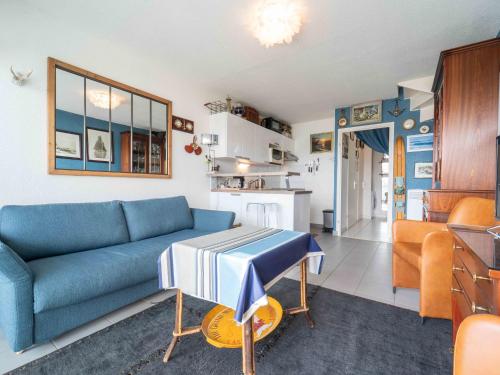 un salon avec un canapé bleu et une table dans l'établissement Appartement pour 4 avec vue sur le courant à Mimizan Plage, parking inclus - FR-1-50-172, à Mimizan