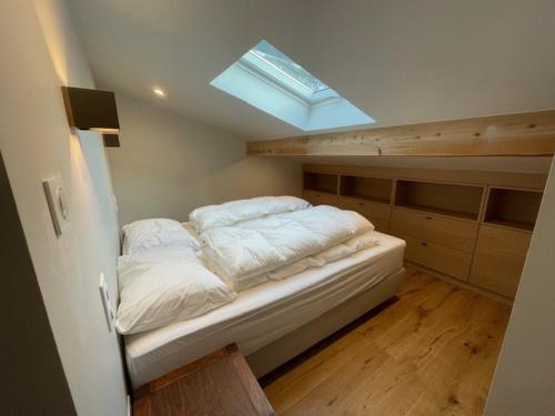 - une petite chambre avec un lit et une lucarne dans l'établissement Spacieux Appartement 5 pièces, 8 pers, Proche centre et remontées, Parking - FR-1-676-220, à Châtel