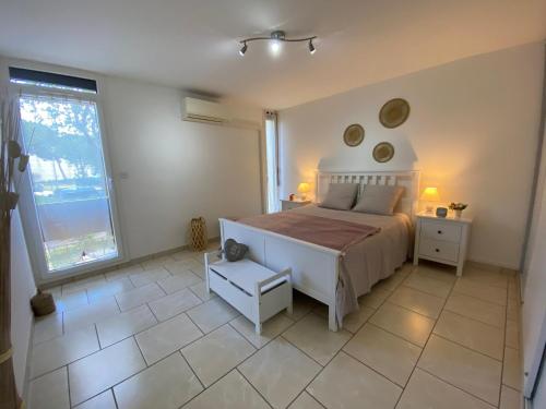 une chambre avec un lit et une grande fenêtre dans l'établissement Appartement confortable 45m², climatisé, Balaruc-les-Bains - FR-1-503-184, à Balaruc-les-Bains
