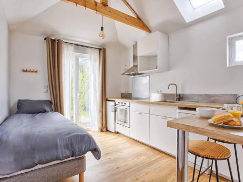 une chambre avec un lit et une cuisine avec une table dans l'établissement Maisonnette cosy indépendante au centre de Merville-Franceville - FR-1-788-64, à Merville-Franceville-Plage